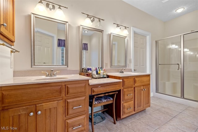 full bathroom with double vanity, a stall shower, and a sink