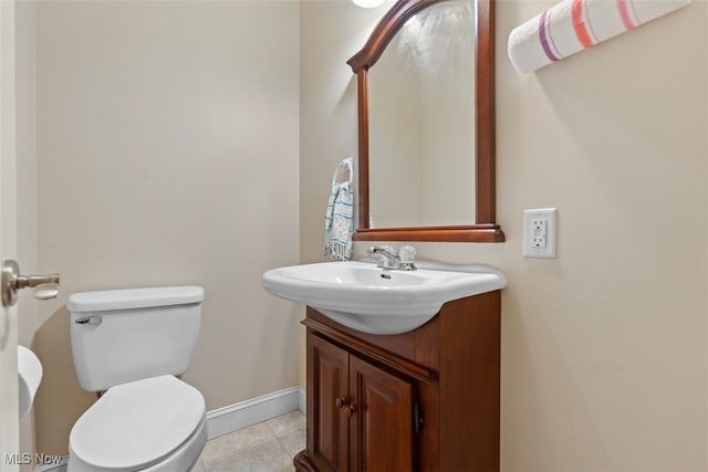 bathroom featuring baseboards, toilet, tile patterned flooring, and vanity