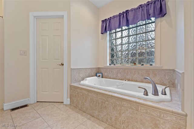 bathroom featuring tile patterned floors, a garden tub, visible vents, and baseboards