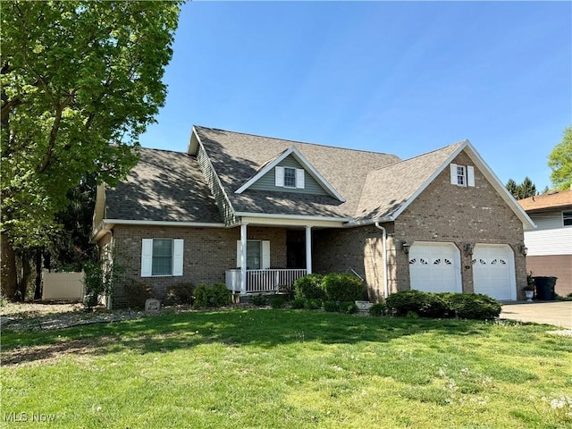 view of front of house featuring covered porch, brick siding, driveway, a front yard, and an attached garage