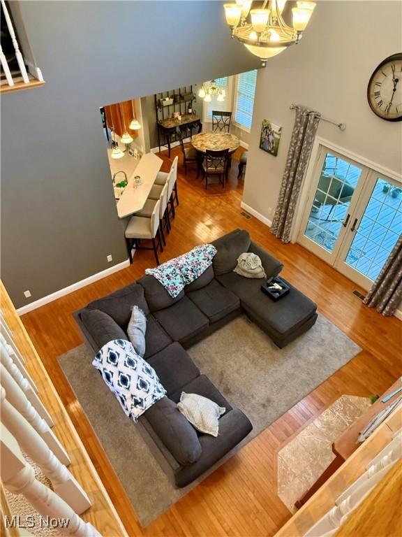 living area featuring a chandelier, baseboards, and wood finished floors