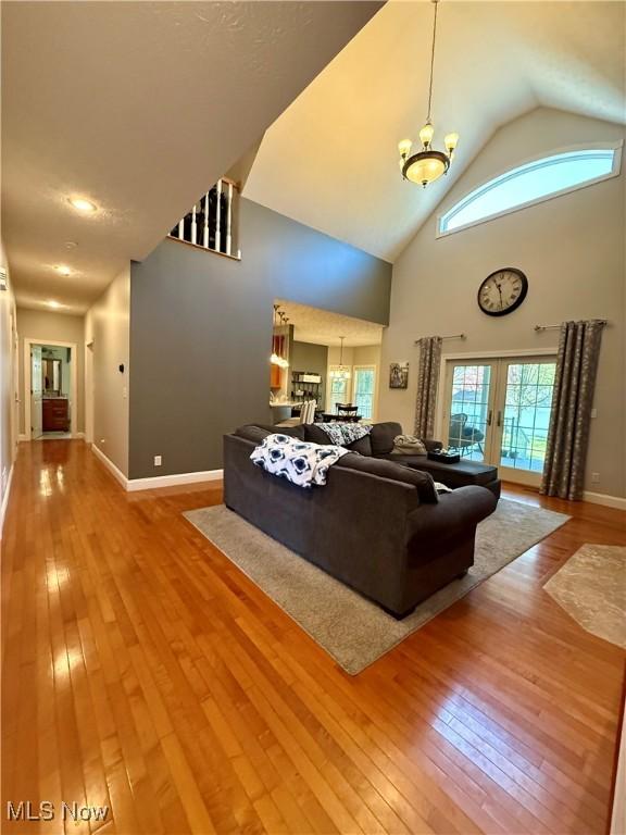 living room with a notable chandelier, hardwood / wood-style flooring, and baseboards