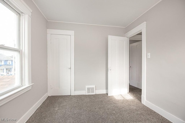 unfurnished bedroom featuring carpet flooring and a closet