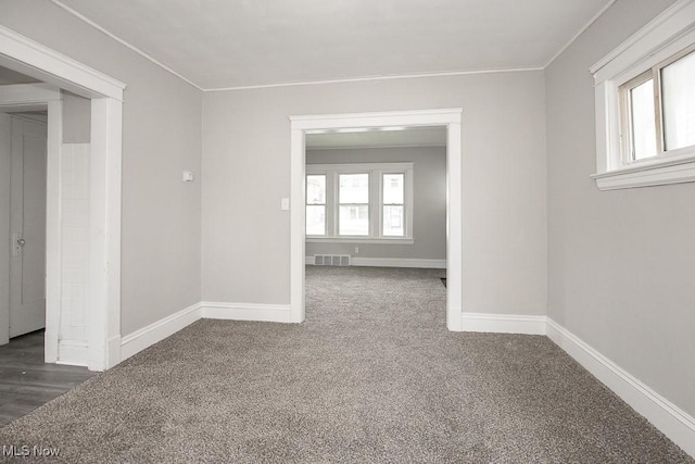 carpeted spare room with a wealth of natural light and ornamental molding