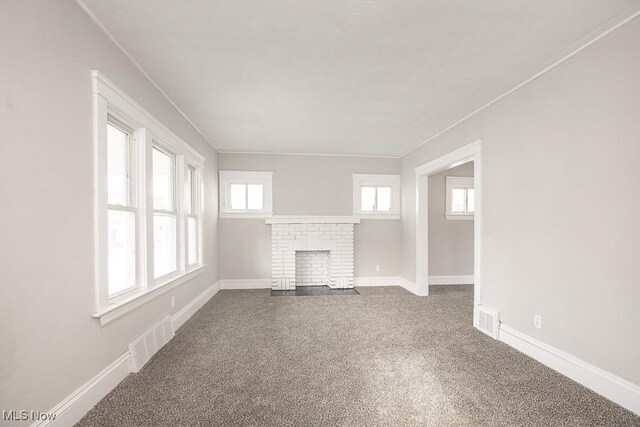 unfurnished living room with carpet floors and a fireplace