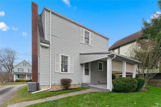 rear view of house featuring a lawn and cooling unit