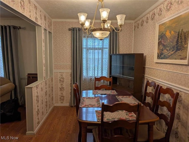 dining space with dark hardwood / wood-style floors, an inviting chandelier, and ornamental molding