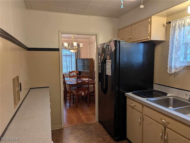 kitchen featuring black fridge with ice dispenser, sink, decorative light fixtures, a notable chandelier, and dark hardwood / wood-style floors