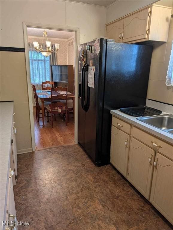 kitchen with a notable chandelier, decorative light fixtures, dark hardwood / wood-style floors, and black fridge