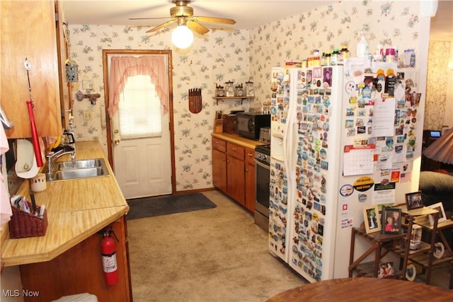 kitchen with light carpet, ceiling fan, sink, white refrigerator, and stainless steel stove