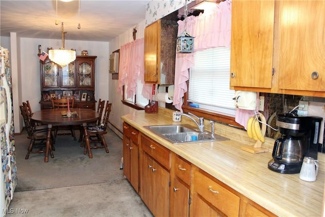 kitchen featuring decorative light fixtures, baseboard heating, and sink