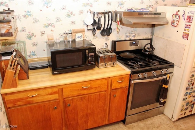 kitchen with stainless steel gas range oven, light colored carpet, exhaust hood, and white refrigerator