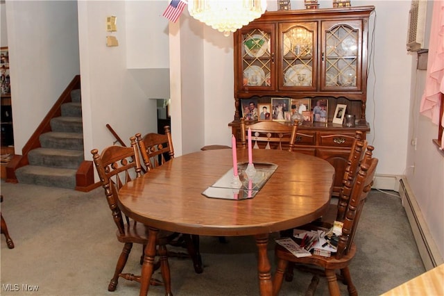 dining space featuring baseboard heating, carpet floors, and an inviting chandelier