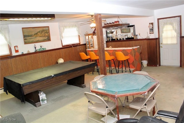 recreation room with carpet, ceiling fan, wooden walls, billiards, and bar