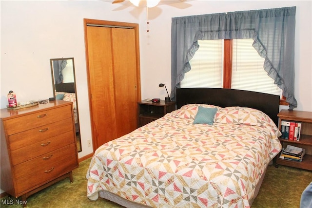 bedroom with dark colored carpet, a closet, and ceiling fan