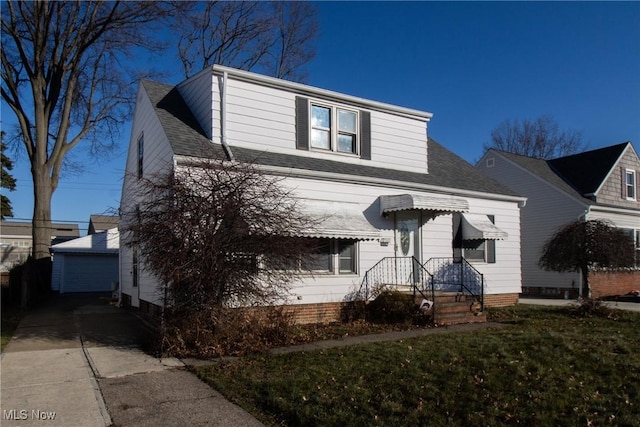 view of property featuring an outbuilding, a garage, and a front yard