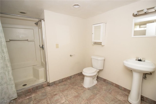 bathroom featuring a shower, toilet, and sink