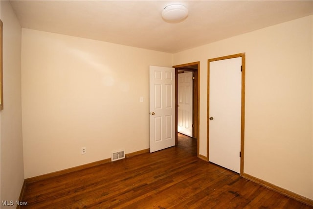 unfurnished bedroom with dark hardwood / wood-style flooring