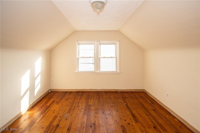 bonus room featuring lofted ceiling and dark hardwood / wood-style floors