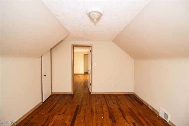 bonus room featuring dark hardwood / wood-style flooring, lofted ceiling, and a textured ceiling