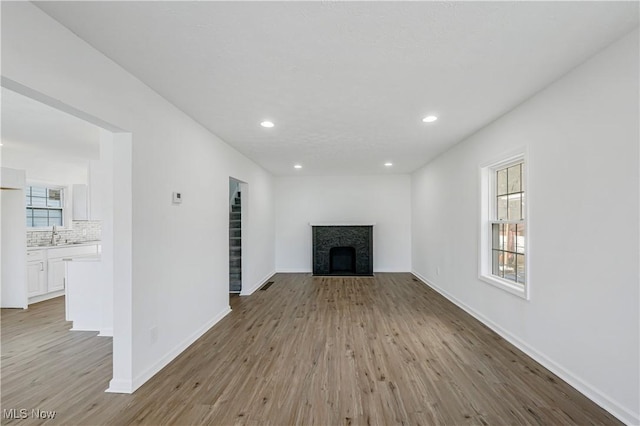 unfurnished living room with light hardwood / wood-style flooring and sink