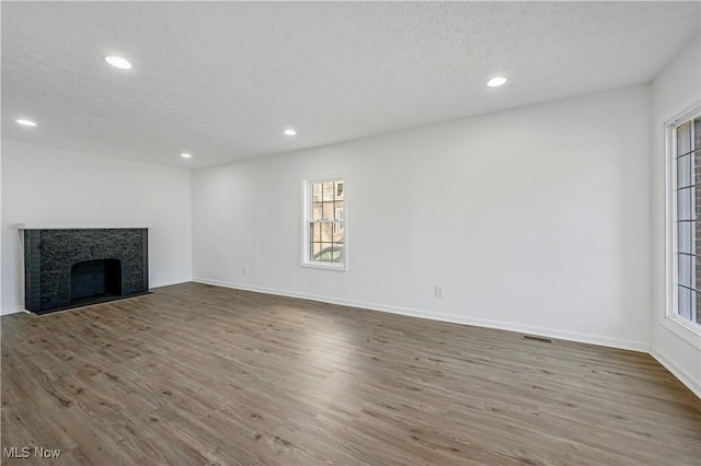 unfurnished living room with a textured ceiling and hardwood / wood-style flooring