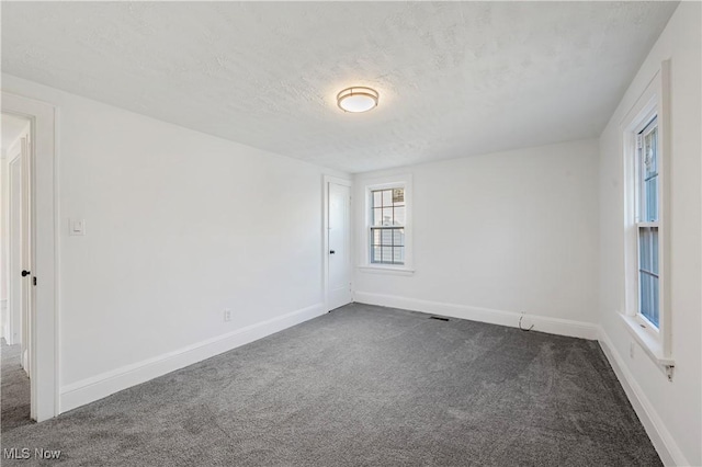 unfurnished room with carpet floors and a textured ceiling