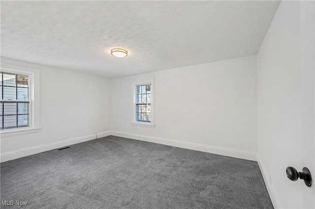 unfurnished room featuring carpet flooring and a textured ceiling