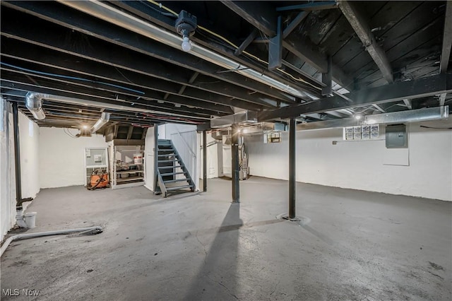 basement featuring electric panel and water heater