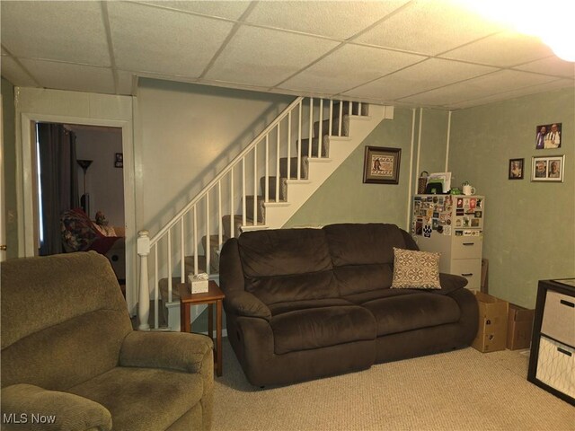 carpeted living room with a paneled ceiling