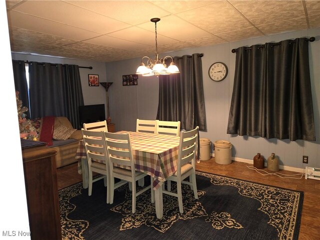 dining area featuring wood-type flooring and an inviting chandelier