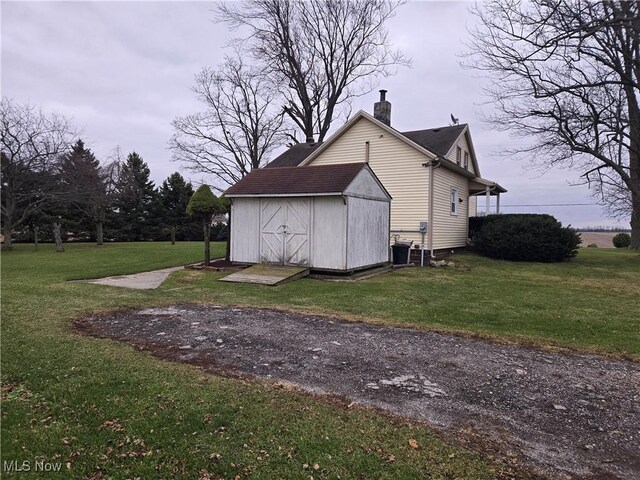 view of outbuilding with cooling unit and a yard