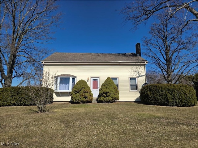 view of front of house with a chimney and a front lawn