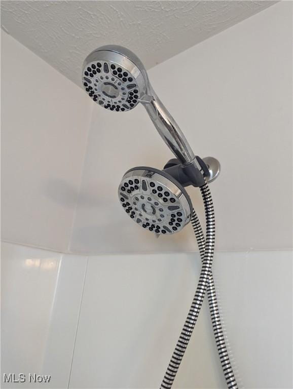 room details with a textured ceiling and walk in shower