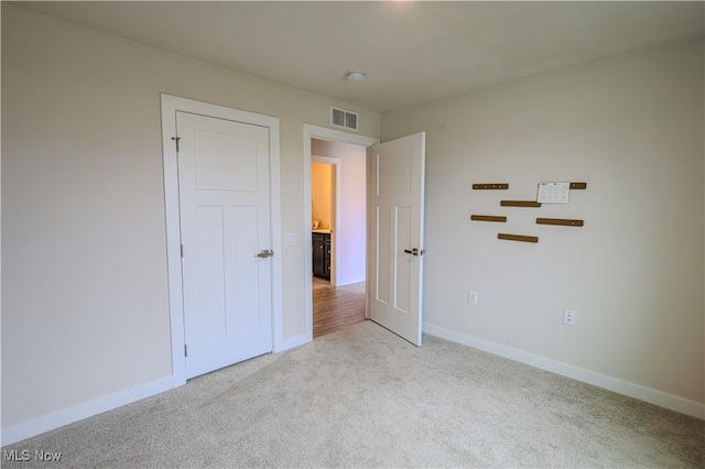 unfurnished bedroom featuring light carpet