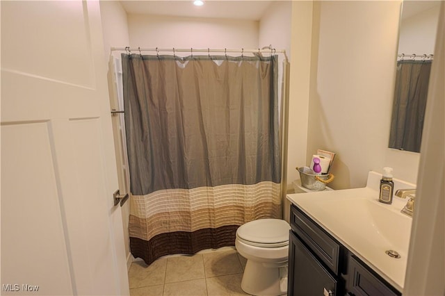 bathroom featuring tile patterned flooring, vanity, toilet, and curtained shower