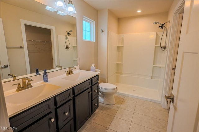 bathroom with a shower, tile patterned flooring, vanity, and toilet