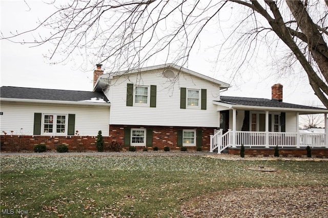 tri-level home featuring a front yard and covered porch