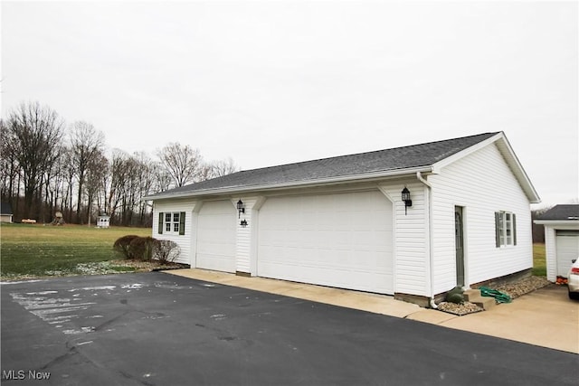 view of side of property with a garage and a lawn