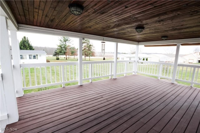 wooden terrace featuring covered porch and a yard