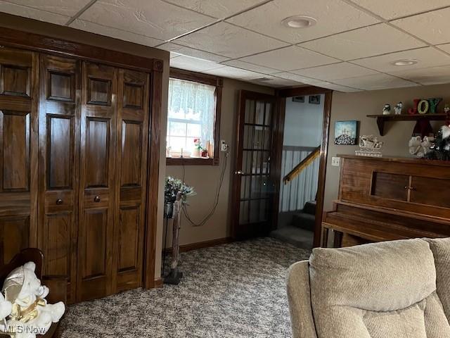 doorway with carpet flooring and a drop ceiling