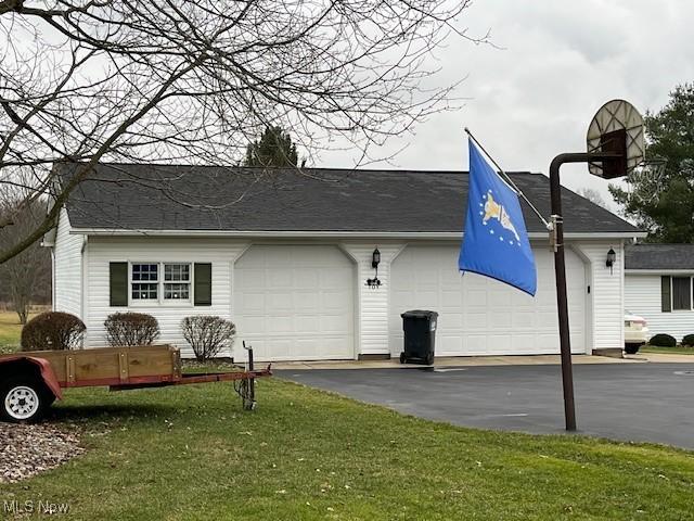 view of side of property featuring a yard and a garage