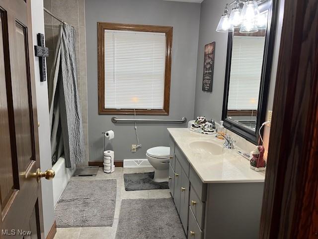 full bathroom featuring toilet, vanity, tile patterned floors, and shower / bathtub combination with curtain