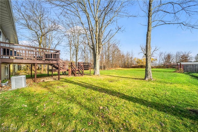 view of yard featuring central AC unit and a wooden deck