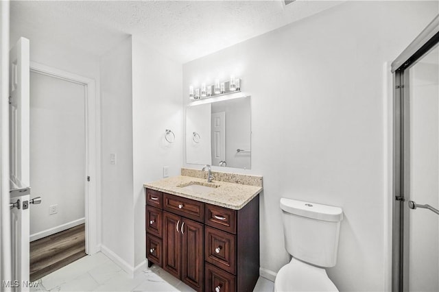 bathroom featuring hardwood / wood-style floors, vanity, a textured ceiling, and toilet