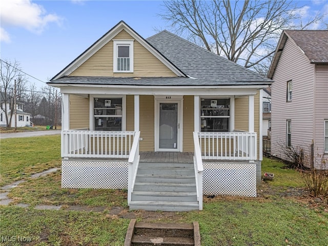 bungalow-style home featuring covered porch and a front lawn