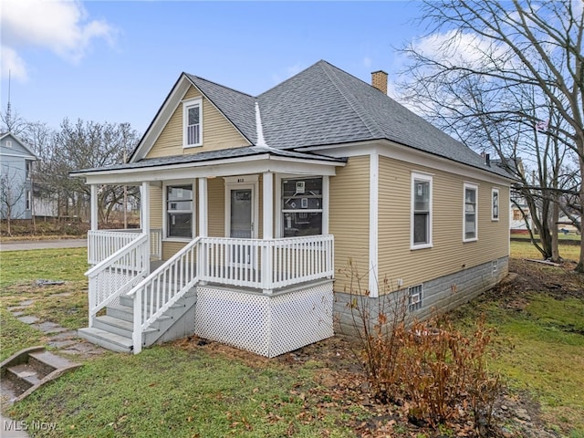 view of front of property with covered porch and a front lawn