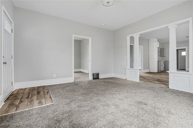 unfurnished room featuring decorative columns, plenty of natural light, and carpet floors