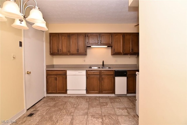 kitchen featuring dishwasher, decorative light fixtures, a textured ceiling, and sink