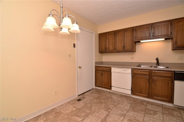 kitchen with dishwasher, sink, a chandelier, pendant lighting, and a textured ceiling